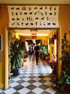 a man walking down a hallway in a building with a sign with dogs at Freehand New York in New York