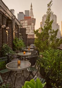 a patio with tables and chairs and a city skyline at Freehand New York in New York