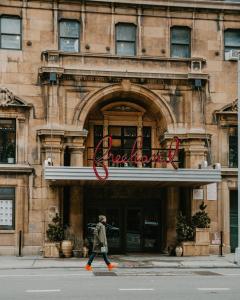 a man walking in front of a building at Freehand New York in New York