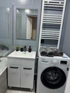 bagno con lavatrice e lavandino di Apartments a Bălţi