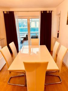 een eetkamer met een witte tafel en stoelen bij Family Apartments Eichel in Rust