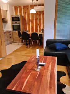 ein Wohnzimmer mit einem Couchtisch aus Holz und einer Kerze darauf in der Unterkunft APARTMA JEREBIKA ŠT. 20 in Hočko Pohorje