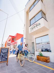 zwei Personen, die vor einem Geschäft Fahrrad fahren in der Unterkunft Hotel Terra Iquique in Iquique