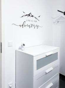 une commode blanche avec un signe moins ordinaire sur un mur dans l'établissement Comfy stay in modern 2-bdr apartment near downtown, à Esch-sur-Alzette