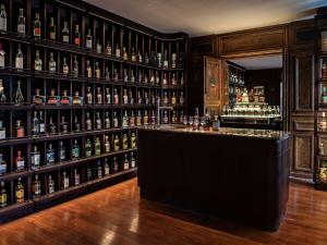 um bar com muitas garrafas de álcool em Domaine Reine Margot Paris - Issy MGallery Collection em Issy-les-Moulineaux