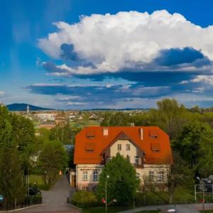 uma casa com um telhado laranja numa cidade em Hotel Sportowy em Świdnica