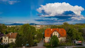 uma casa com telhado de laranja numa cidade com árvores em Hotel Sportowy em Świdnica