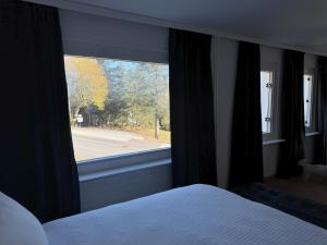 1 dormitorio con cama y ventana grande en Crans Montana Suites, en Crans-Montana