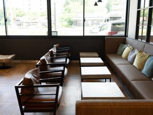 uma fila de cadeiras e um sofá num quarto em Super Hotel Fujikawaguchiko Tennenonsen em Fujikawaguchiko