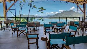 um restaurante com cadeiras e mesas e vista para a água em Catalina Hotel em Ubatuba