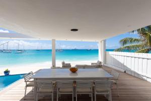 une salle à manger avec une table et des chaises et l'océan dans l'établissement Villa Impala - Front sea 5BR in Simpson Bay, Sint Maarten, à Simpson Bay