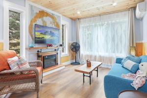 sala de estar con sofá azul y TV en Avonlea Forest Hill Cottages, en New Glasgow