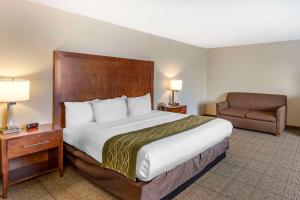 um quarto de hotel com uma cama grande e uma cadeira em Comfort Inn Denver West Arvada Station em Wheat Ridge