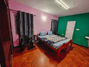 a bedroom with a bed and green and pink walls at hilldown cottage in Ooty