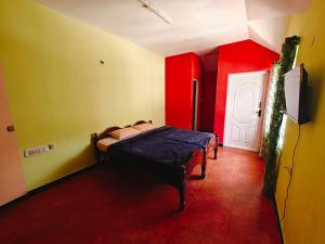 a bedroom with red and yellow walls and a bed at hilldown cottage in Ooty