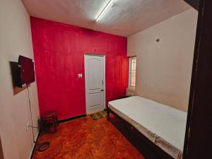 a red room with a bed and a red wall at hilldown cottage in Ooty