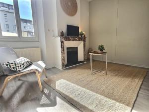 sala de estar con chimenea, silla y mesa en Relais 1 - Appartement centre ville, en Bourg-de-Péage