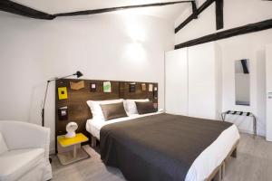 een slaapkamer met een groot bed en een stoel bij TorinoToStay Apartments in Turijn