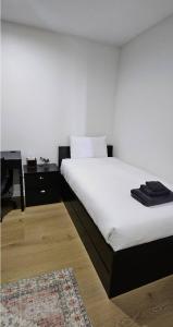 een slaapkamer met een wit bed en een tapijt bij Rouse Hills TownCentre luxury accommodation in Kellyville