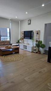 een woonkamer met een bank en een tv bij Rouse Hills TownCentre luxury accommodation in Kellyville