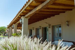 eine Veranda eines Hauses mit einem Holzdach in der Unterkunft El Porvenir Wine Lodge in Cafayate