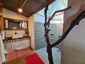 La salle de bains est pourvue d'un lavabo et d'un arbre. dans l'établissement KINTANA LODGE, sur l'île aux Nattes