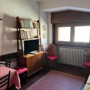 a room with a tv and a book shelf at appartamento Cervinia fronte Funivie in Breuil-Cervinia