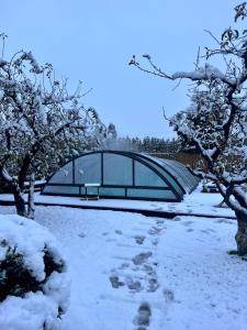 un edificio con una facciata in vetro nella neve di Orchard Villa a Braşov