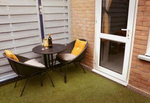 uma mesa de pátio com 2 cadeiras e uma garrafa de vinho em Stylish Studio Flat With Private Patio em Bournemouth