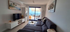 uma sala de estar com um sofá e uma televisão em Sea view cozy apartment La Tanita em Mojácar