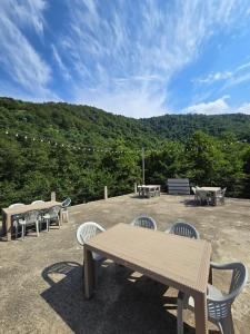 eine Gruppe von Picknicktischen und Bänken auf einer Terrasse in der Unterkunft Rcheuli Villa in Charnali in Batumi