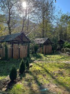 zwei Pavillons in einem Garten mit einem Zaun in der Unterkunft Rcheuli Villa in Charnali in Batumi