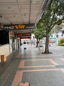 een lege stoep in een winkelcentrum met een boom bij Alison's central apartment in Cabramatta