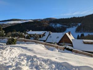 a snow covered roof of a house with mountains in the background at La source in Sondernach