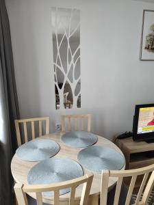 mesa de comedor con 4 sillas y TV en Apartament Praski 5 minut od metra i starego miasta spacerem do zoo i Konesera, en Varsovia