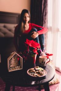 une femme assise dans une chaise à côté d'une table avec une bougie dans l'établissement Business Hotel Plovdiv, à Plovdiv