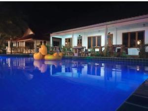 ein Schwimmbad in der Nacht mit einem Resort in der Unterkunft Pai Family Resort in Pai