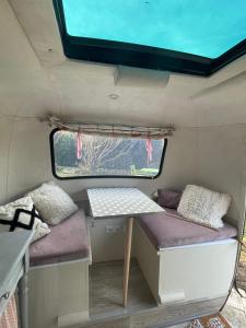 een tafel en een bank achterin een trailer bij Salève Glamping in Archamps