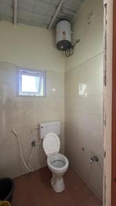 a bathroom with a toilet and a window at AG Cottage Vattakanal in Kodaikānāl