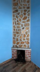 a stone fireplace in a room with a blue wall at AG Cottage Vattakanal in Kodaikānāl