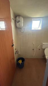 a bathroom with a toilet and a window at AG Cottage Vattakanal in Kodaikānāl