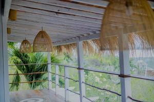 um alpendre com vista para uma palmeira em The Puncak Private Villa em Nusa Lembongan