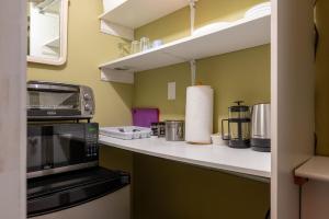 a kitchen with a counter top with a microwave at Auberge Old Chelsea in Chelsea