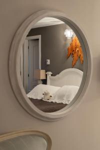 a mirror reflecting a bed in a bedroom at Auberge Old Chelsea in Chelsea