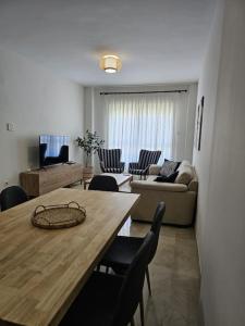 ein Wohnzimmer mit einem Tisch, Stühlen und einem Sofa in der Unterkunft Apartamento en Dos Hermanas La Motilla in Dos Hermanas