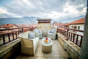 a balcony with chairs and a table on a balcony at Velinov Boutique Hotel in Bansko