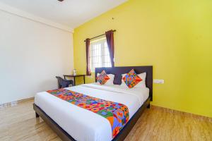 a bedroom with a large bed with colorful pillows at FabHotel Saro Sri Residency in Coimbatore