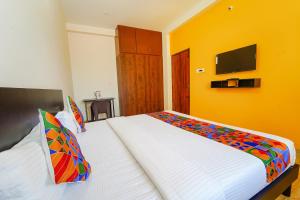 Una cama o camas en una habitación de FabHotel Saro Sri Residency