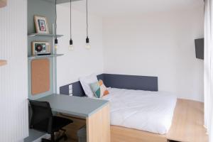 een kleine slaapkamer met een bed en een bureau bij Résidence Kley Clichy in Clichy