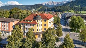 um grande edifício amarelo com um telhado vermelho em Hotel Vier Jahreszeiten em Garmisch-Partenkirchen